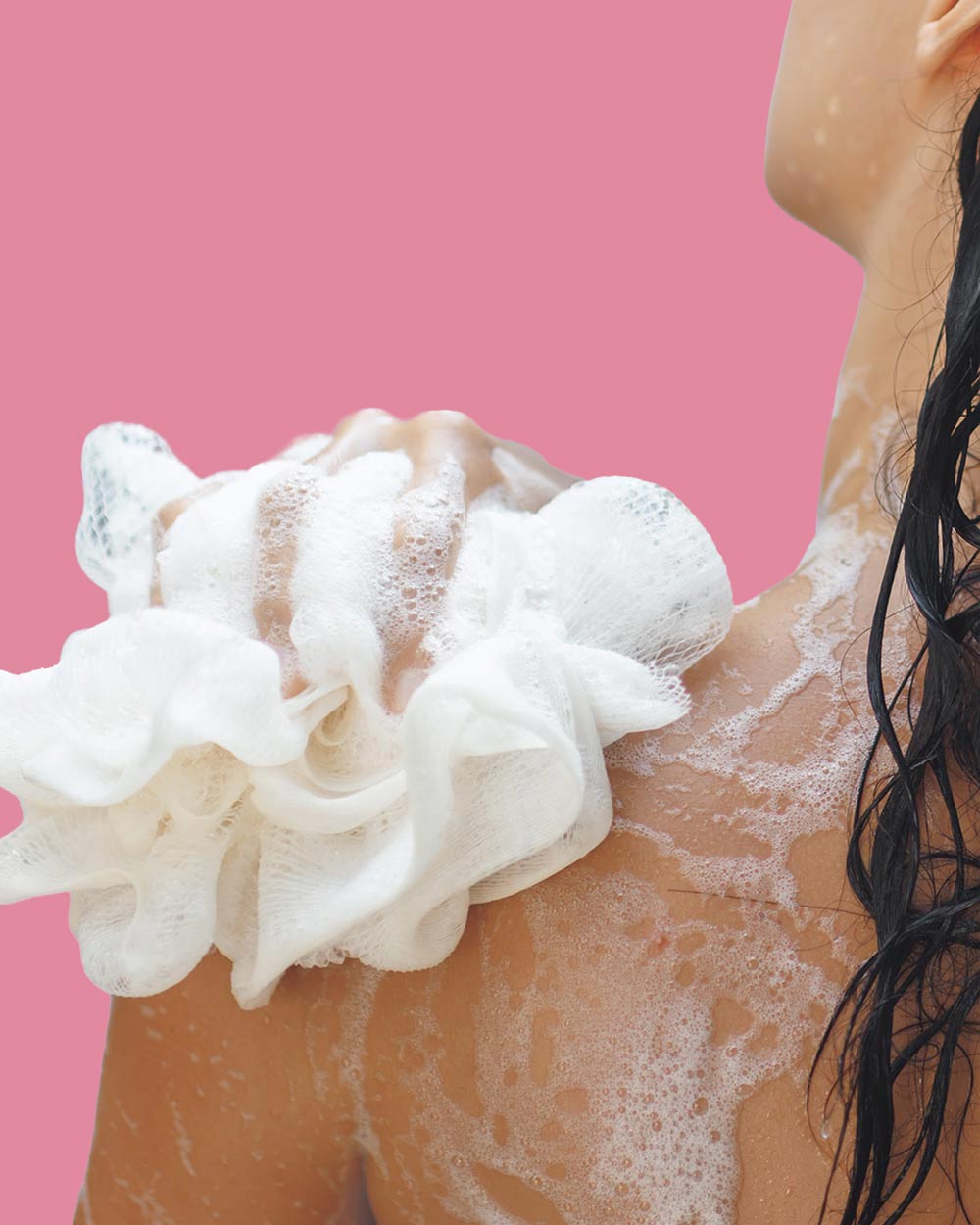 Frau seift sich unter der Dusche ein